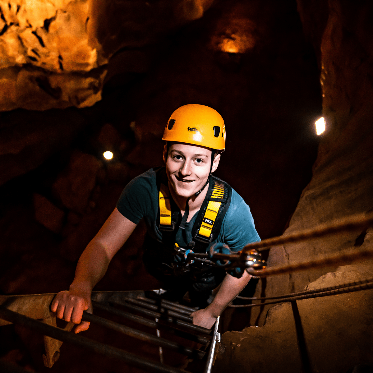 A visitor climbs up the ladder, looking at the camera, ready to complete the Black Cat Freefall activity. 