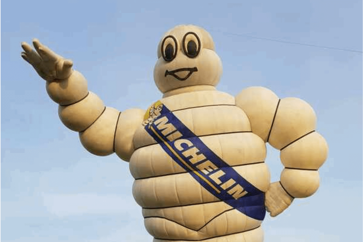 Michelin man as a balloon. A man appearing to be made of white tyres.