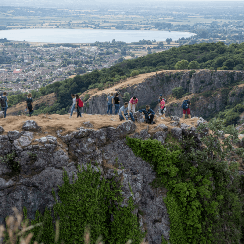 A landscape shot of the cliff-top walk at Cheddar, with a group enjoying the scenic and expansive view from the top