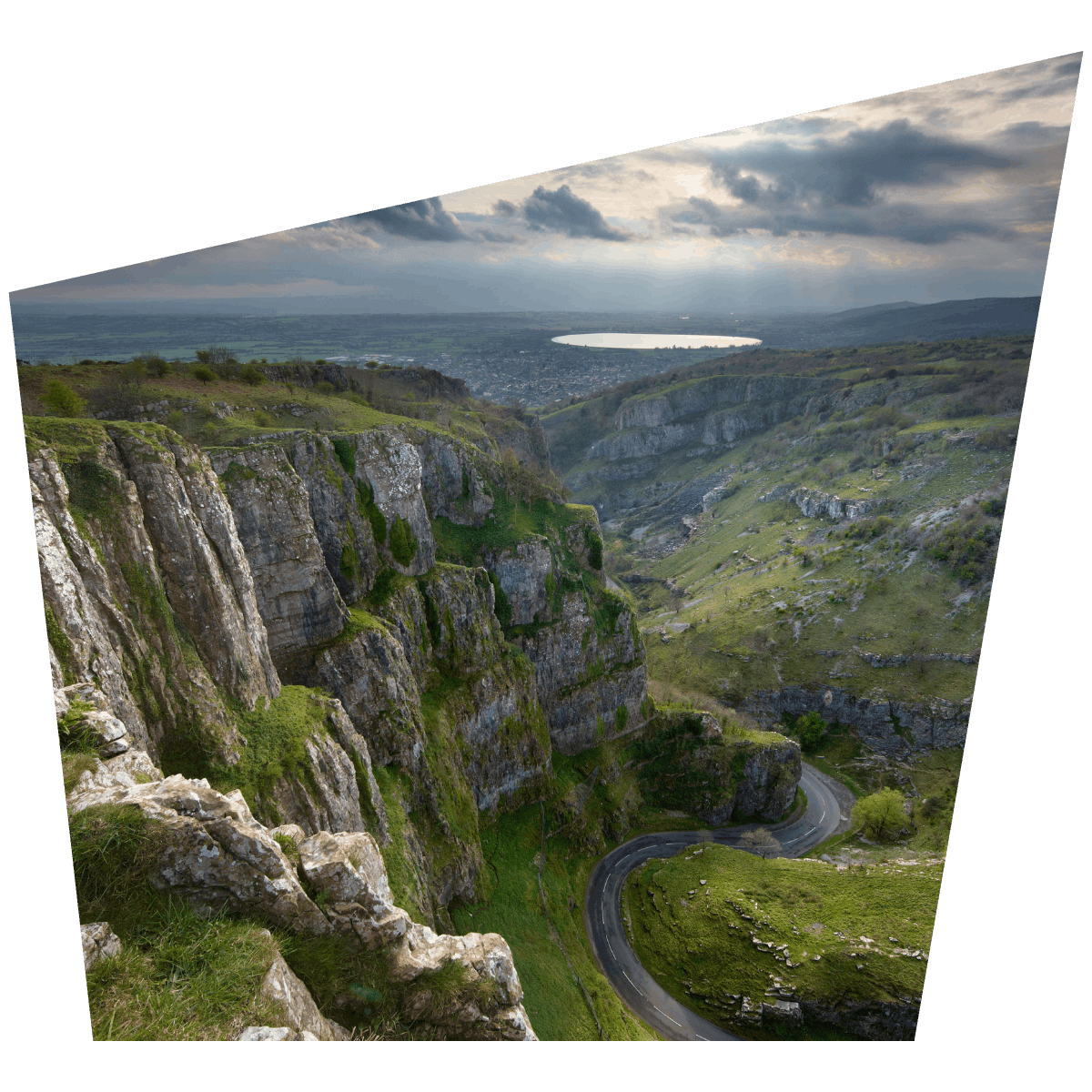 Dramatic cliffs at cheddar gorge and caves showing view down the caves with views in the background of the lake at cheddar in somerset plan your day