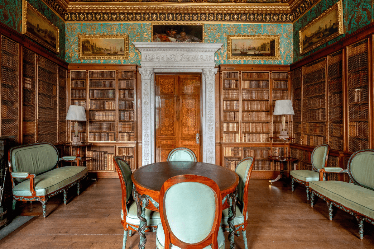 A wide shot of the green library with books, art and furniture on display