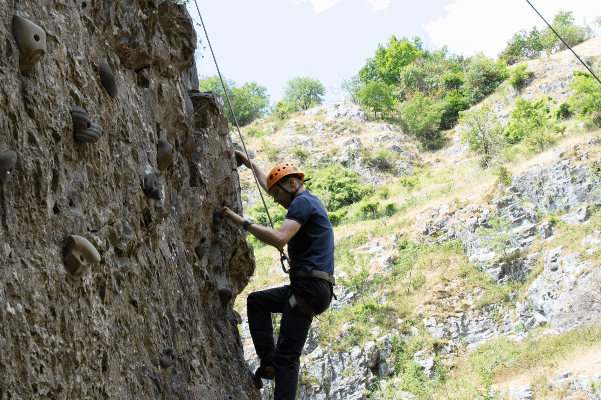A visitor enjoys a climb on one of the Cheddar Rock formations