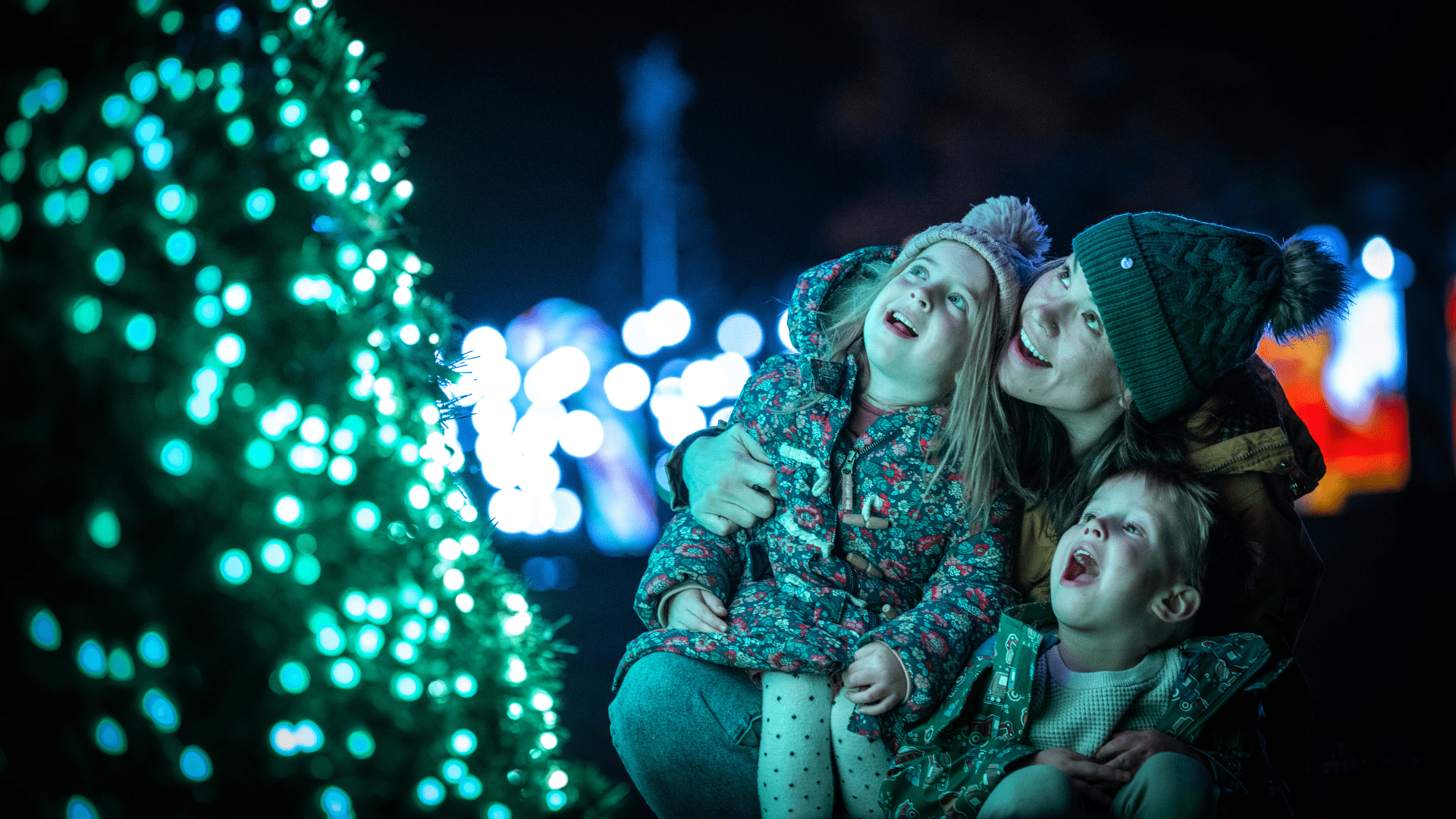 A family admire the sparkling lights of The Enchanted Christmas Tree Show