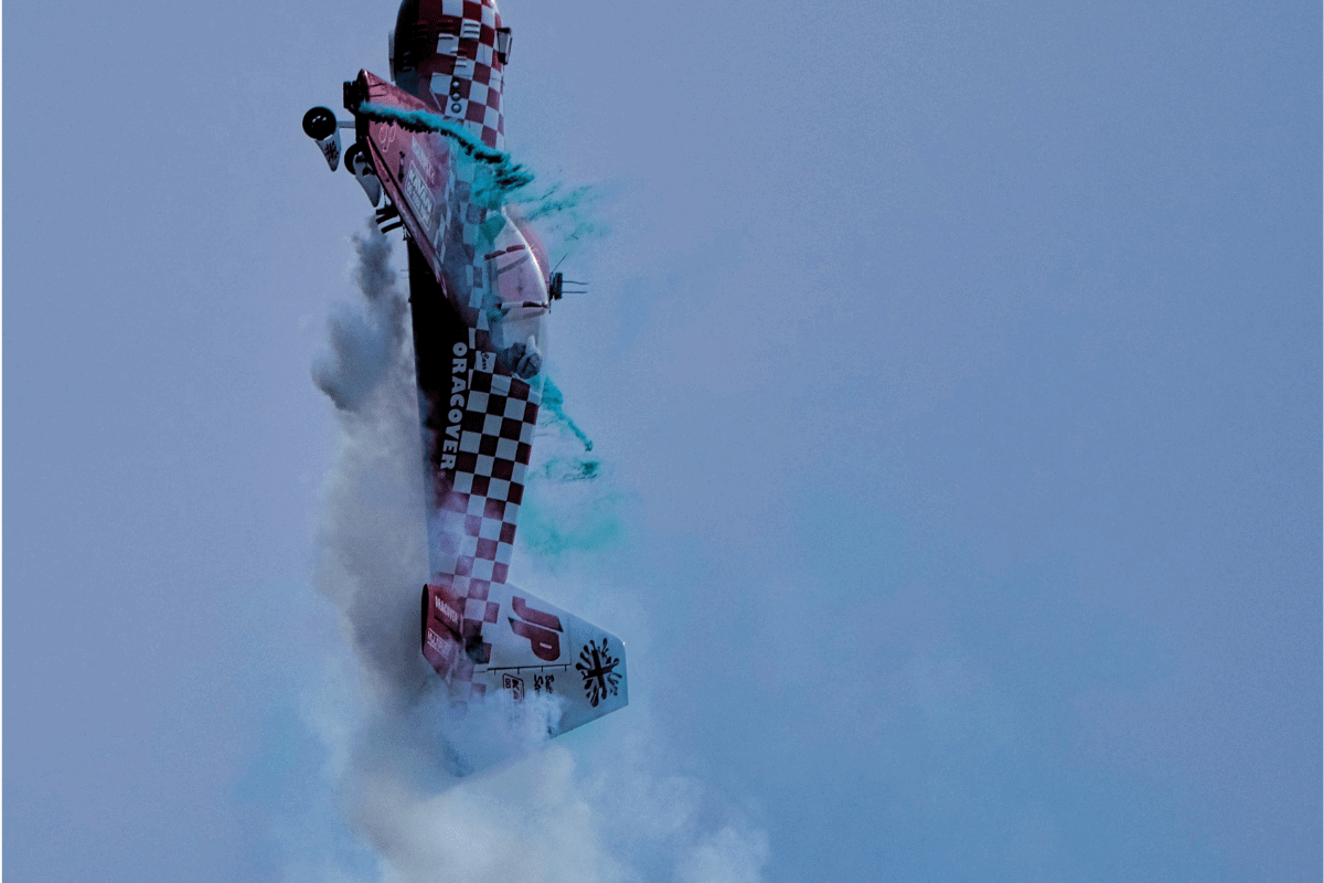 A Yak model plane flying vertically in the sky