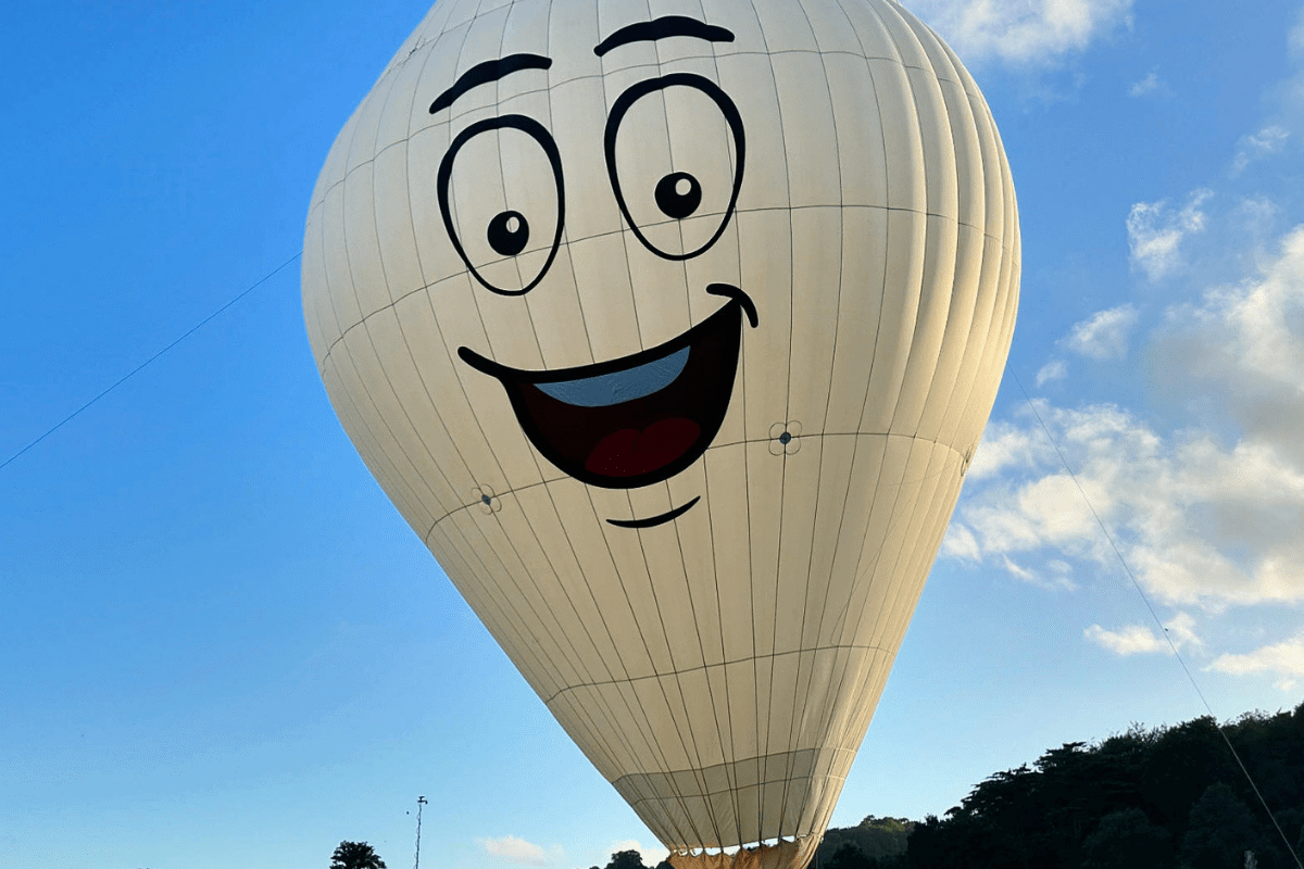 A white balloon with a painted smiling and animated face