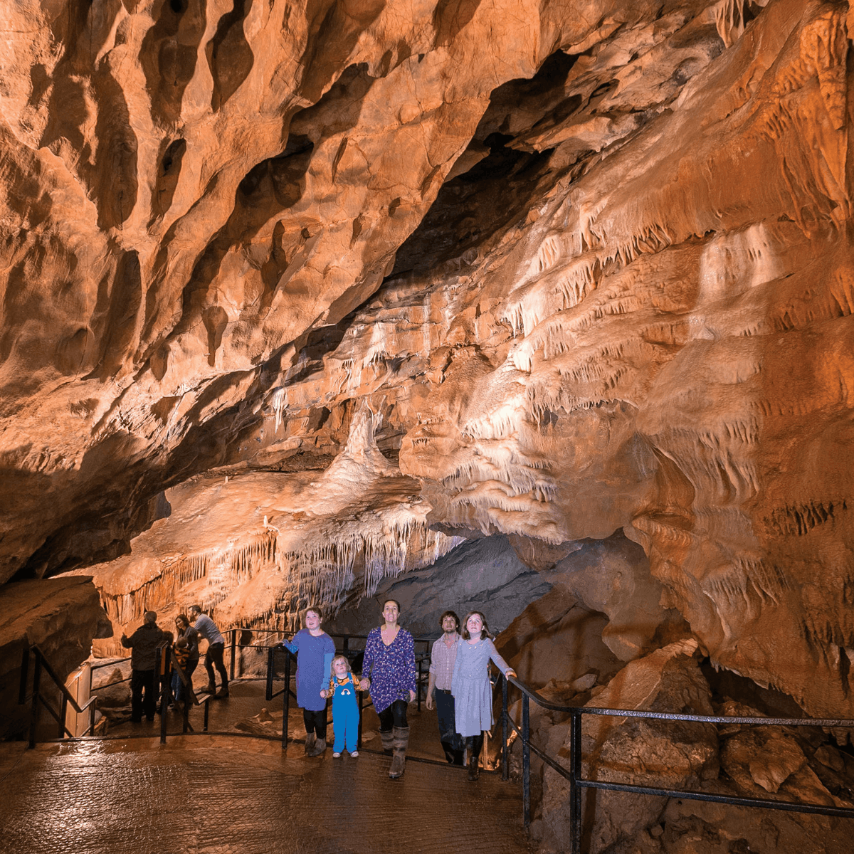 A family walks through a large cave