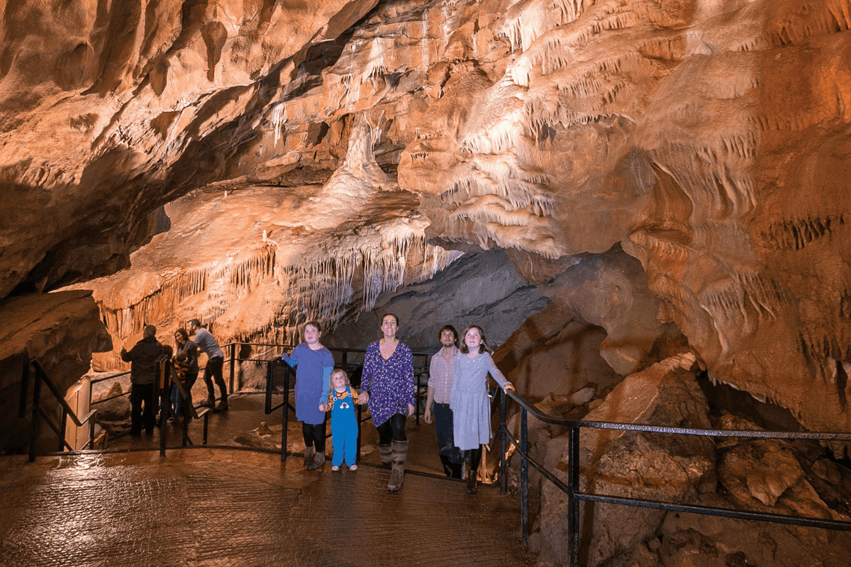 A family walks through a large cave