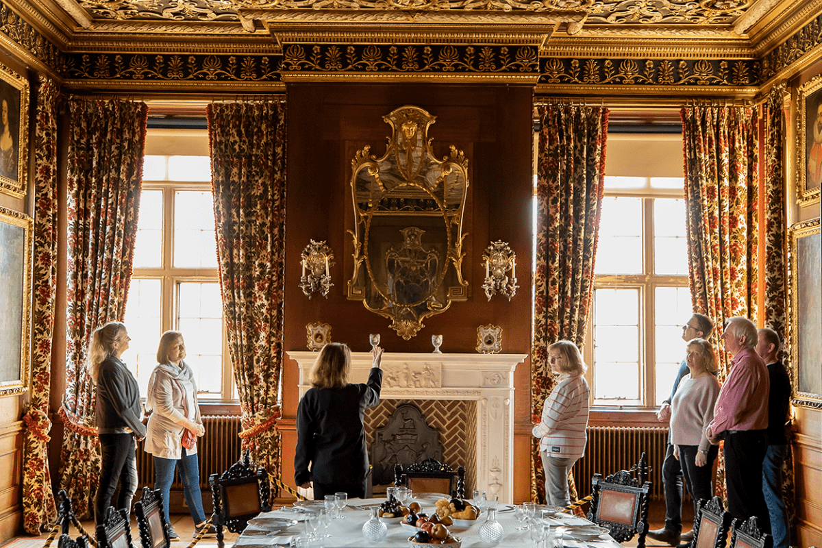 A group of visitors admire the grand ceiling in one of the dining rooms whilst on a guided tour of Longleat House