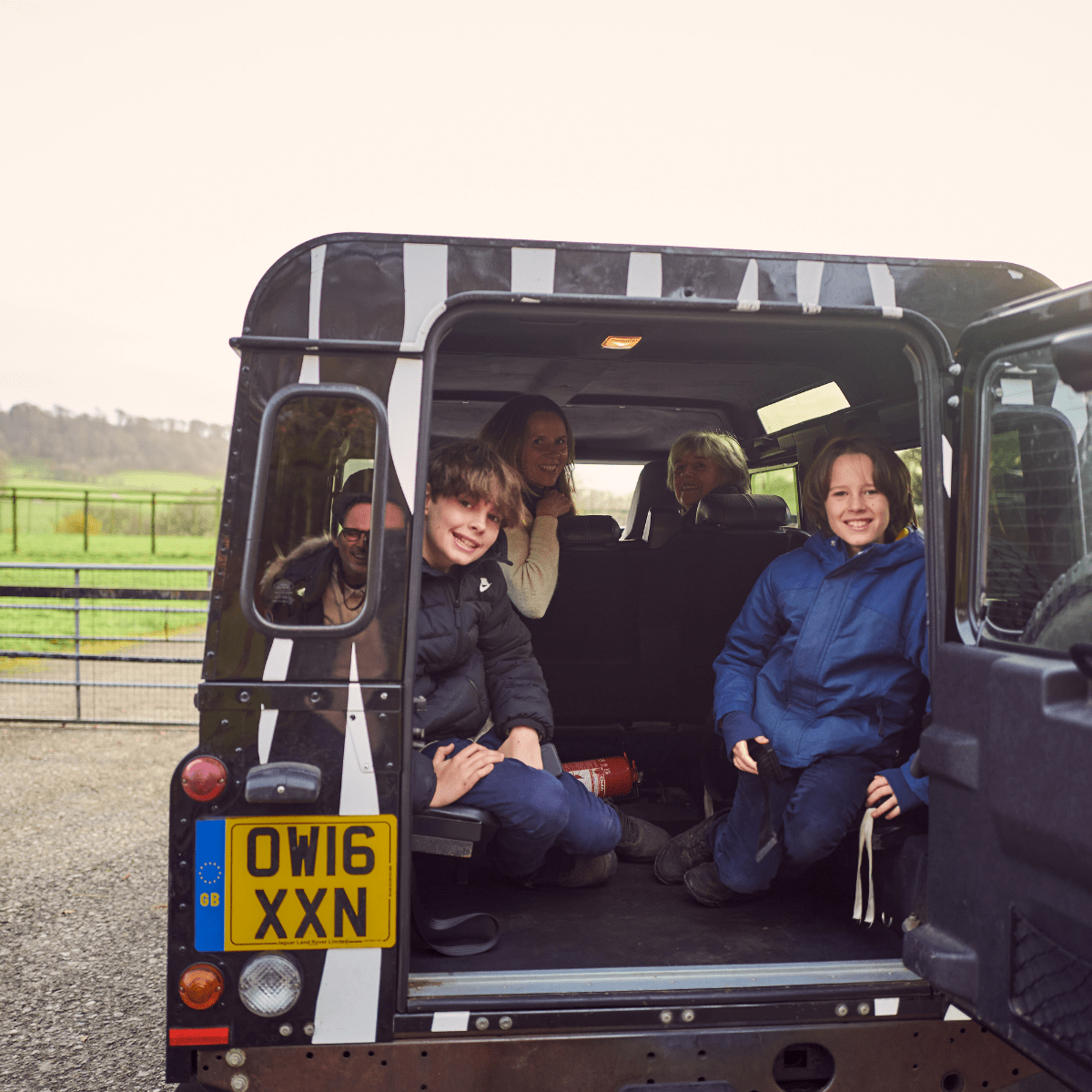 A family smile perched in the back of the iconic 4x4 zebra print VIP truck