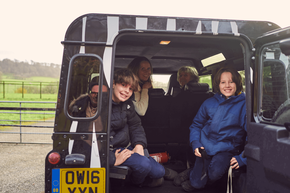 A family smile perched in the back of the iconic 4x4 zebra print VIP truck