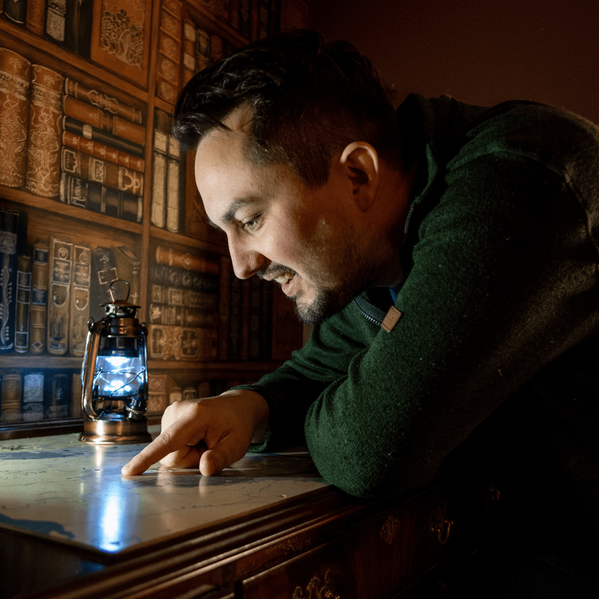 A man looks at a potential clue in the escape rooms at Cheddar. He peers at a map looking for answers