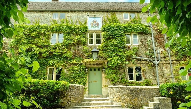 The Bath Arms Pub - an old building with climbing ivy and a sage green front door.