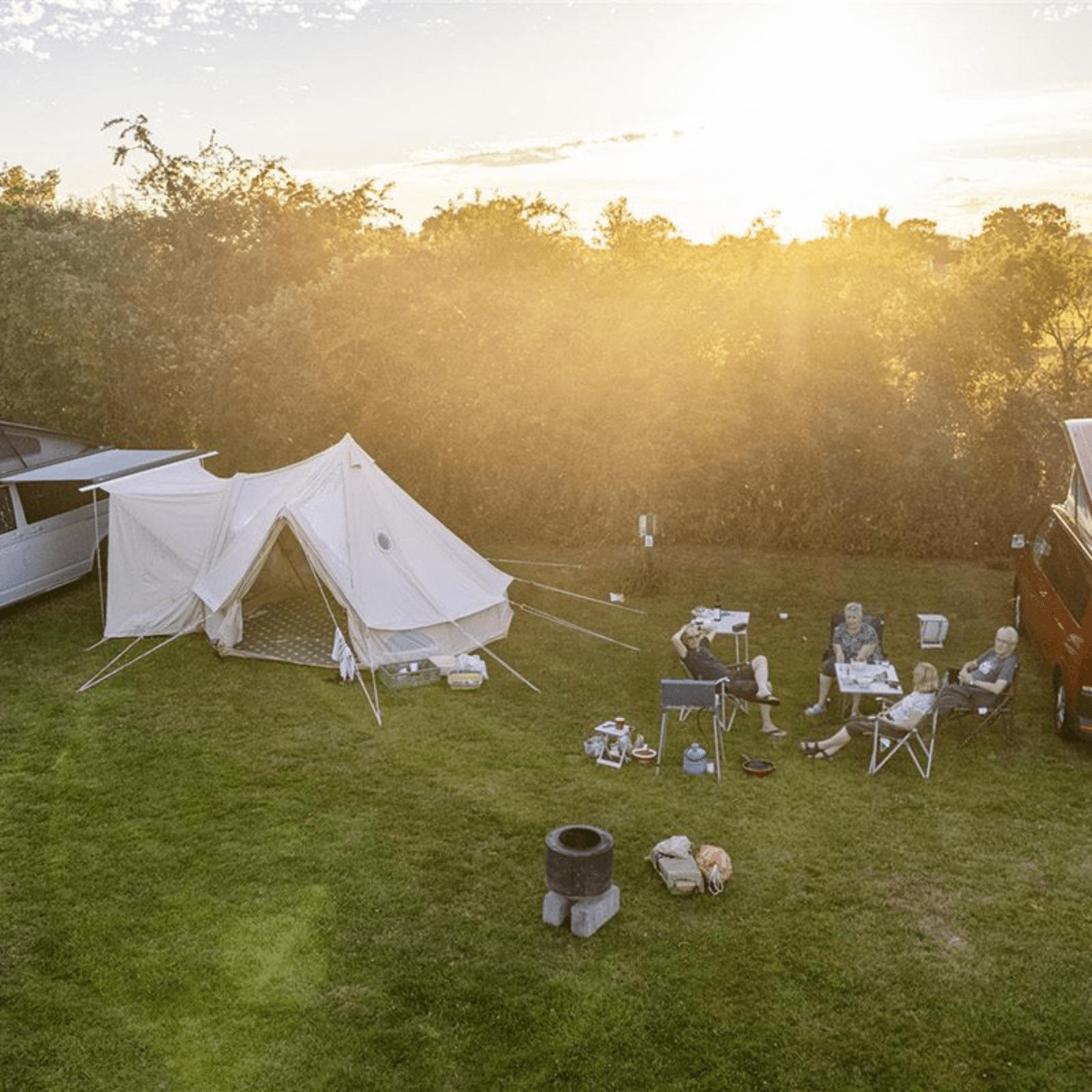 A group enjoy the outdoors as they sit next to their tent set up at Greenacres camping