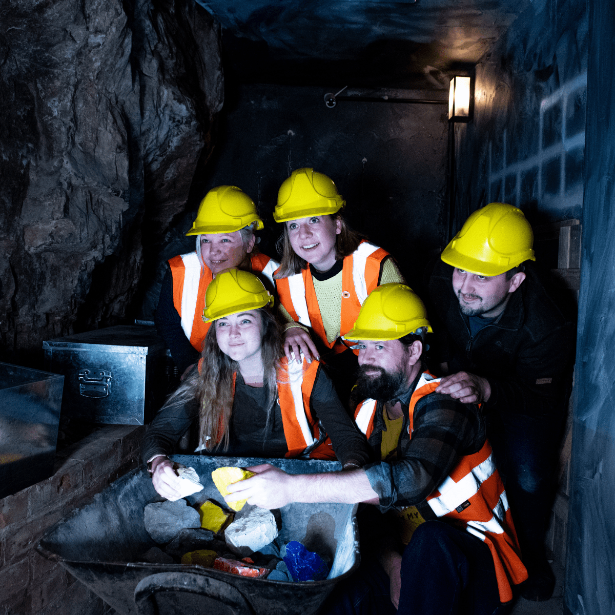 A group of people look at a potential clue in the escape rooms at Cheddar. They gather round a clue looking for answers