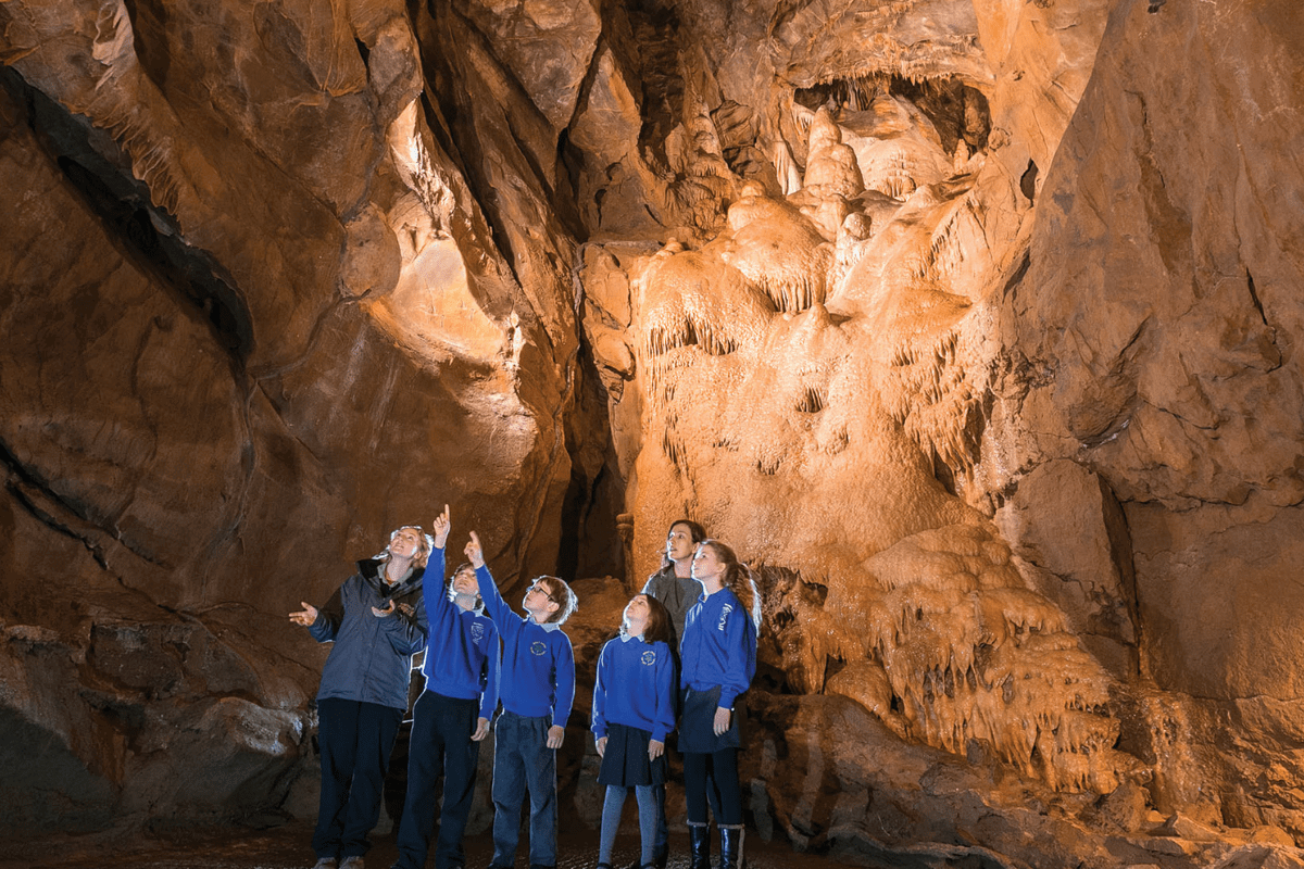A group of school children along with their teachers admire the impressive rock formations in Gough's cave