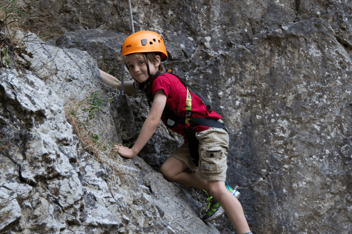 A young visitor climbs one of the rock formations at Cheddar Gorge