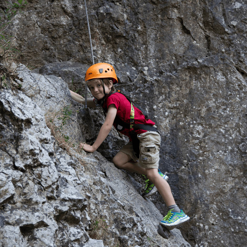 A young visitor climbs one of the rock formations at Cheddar Gorge