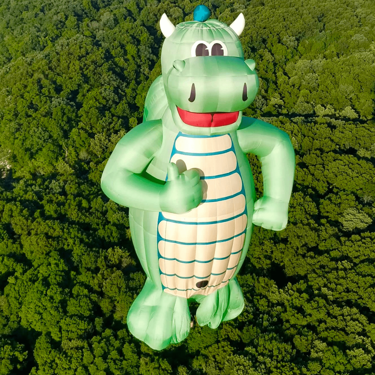 A balloon shaped like a green, smiling dragon