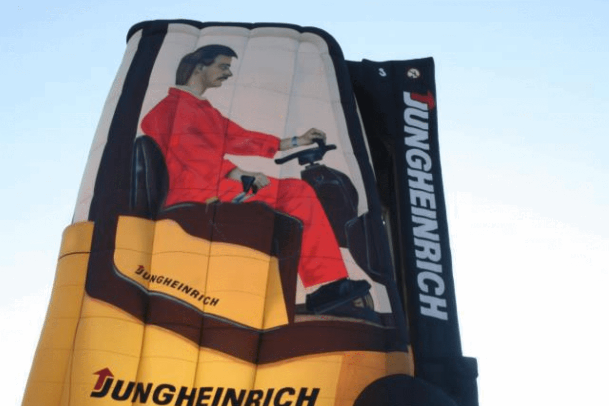 A balloon shaped like a forklift truck with a man driving