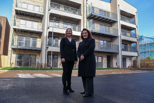 Two women smiling and standing in front of the 359 Staines Road Development building