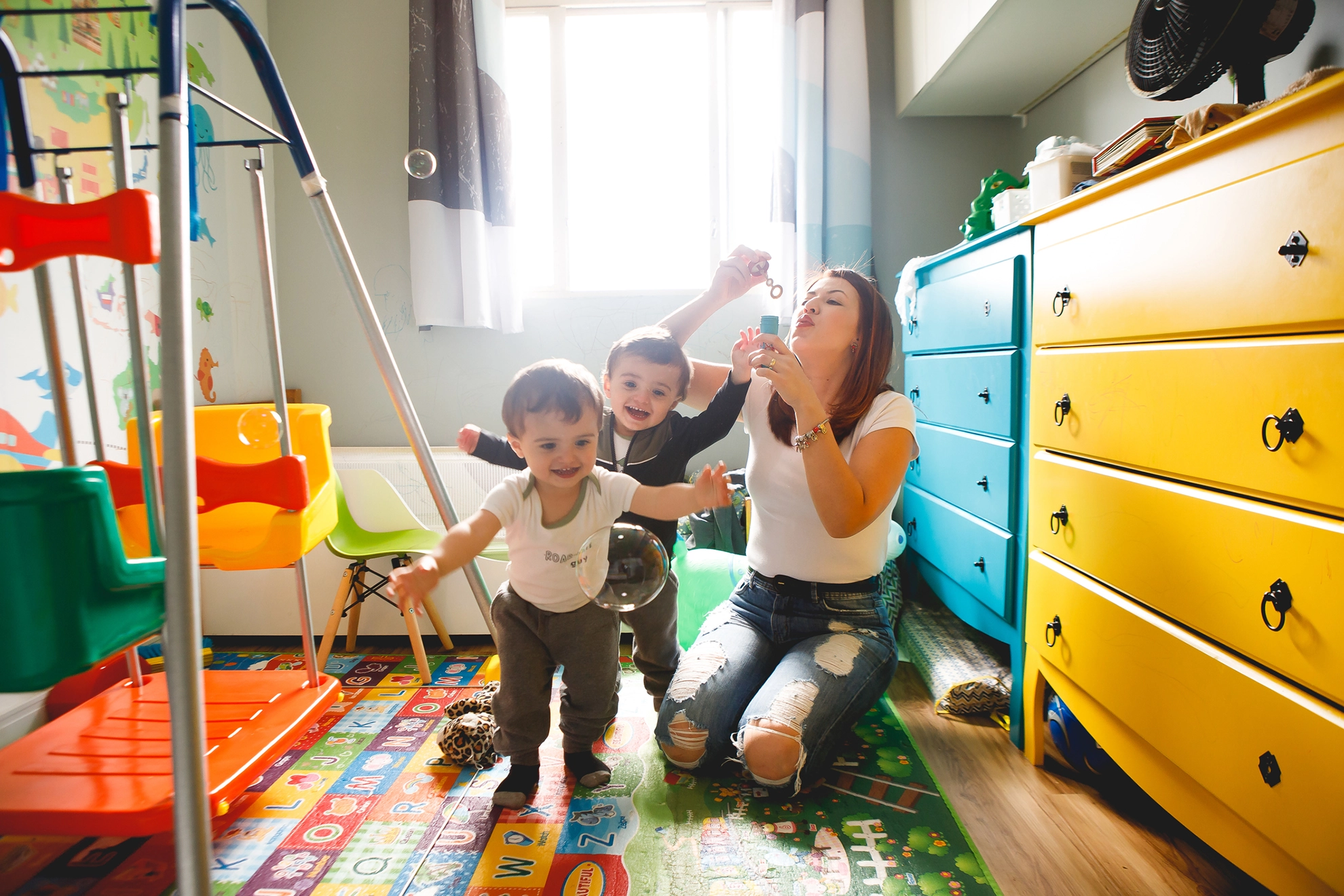 Mum blowing bubbles for kids in bedroom