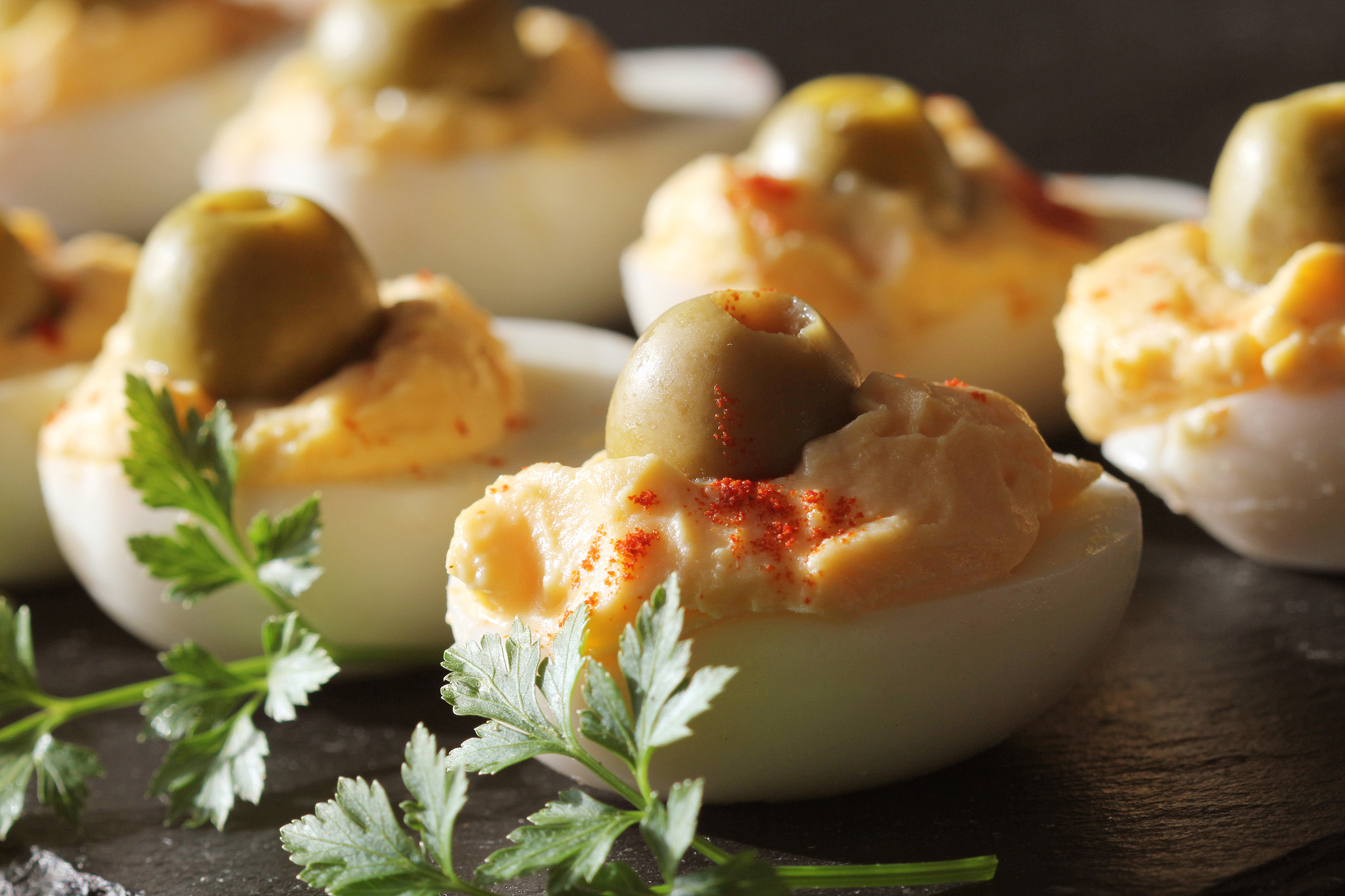 Spicy Deviled Eggs Garnished With Green Olives Parsley