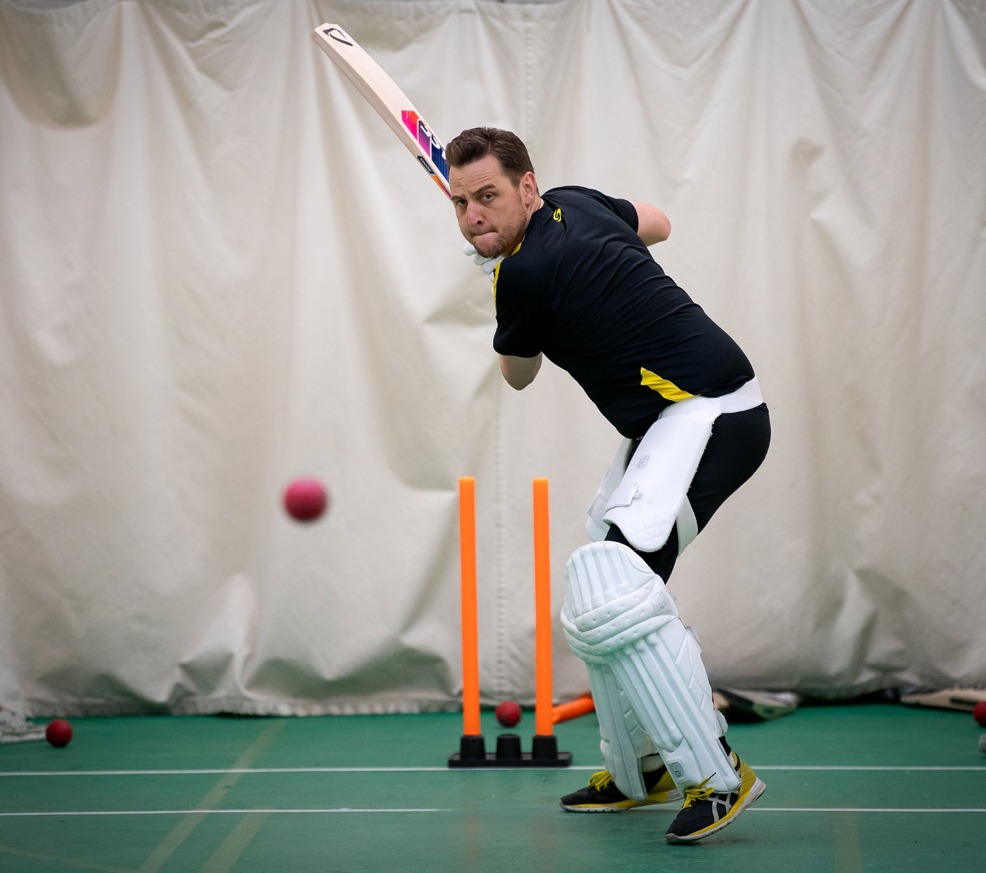 Adam Collins with a huge back swing to smash a ball in the nets with a Chase Cricket bat 