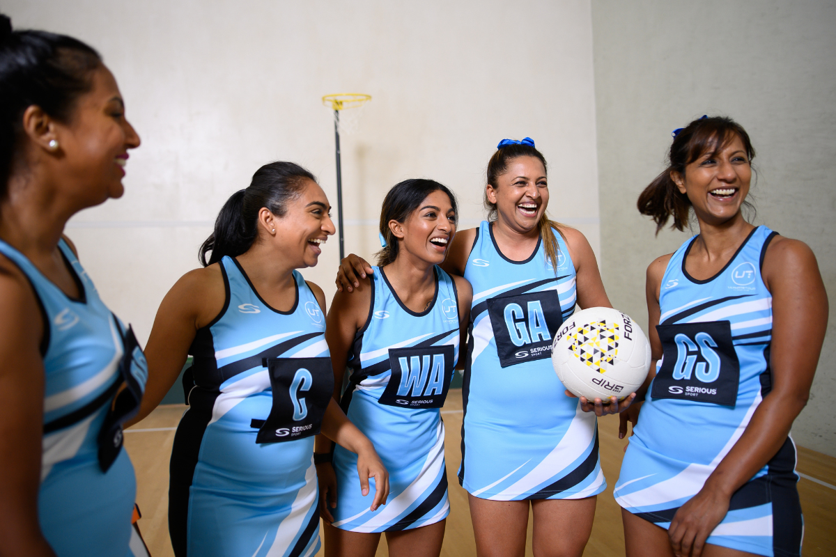 Group of netballers in their sky blue Serious Sport netball dresses