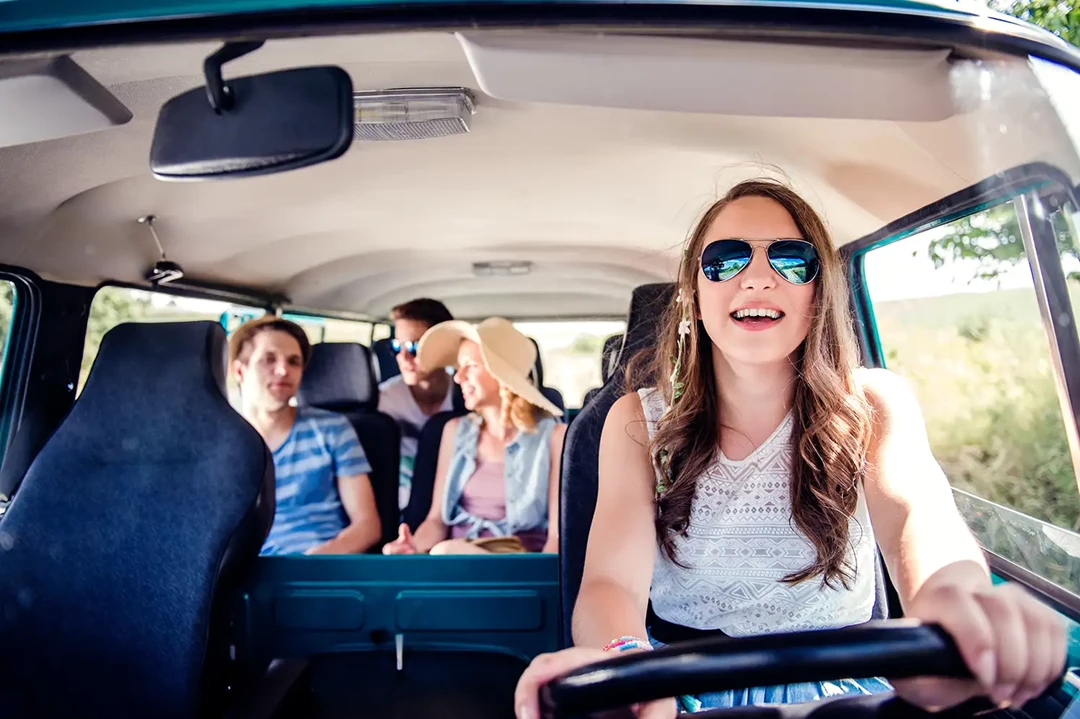 Young mother driving with children in the back