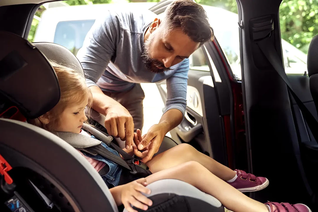 Father strapping his child into the car