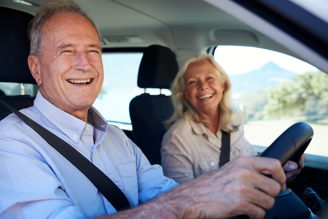 Middle aged couple on a pension driving their new car