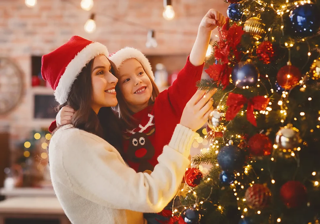 Christmas at home with mother and daughter decorating the Christmas tree