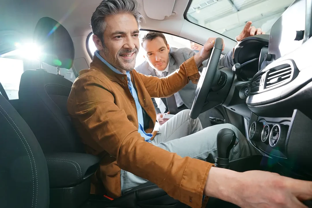 Man checking a used car before buying.