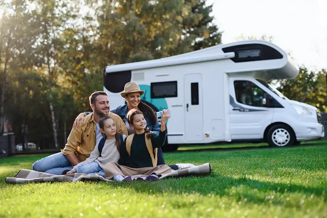 Family having a picnic while enjoying their campervan in the countryside.