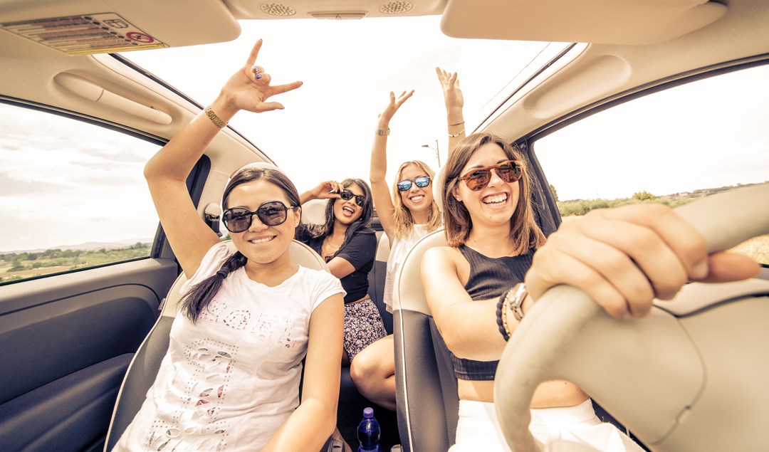 Group of young ladies driving on open road