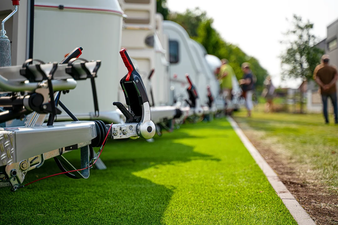 Row of caravans on green grass next to a path