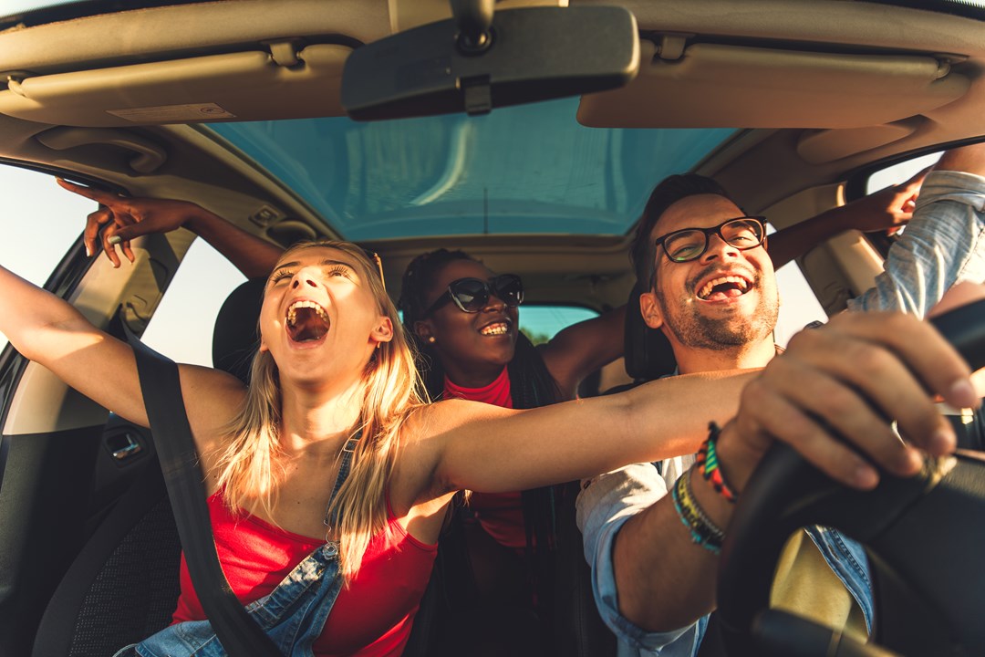 Group of young adults enjoying a car ride