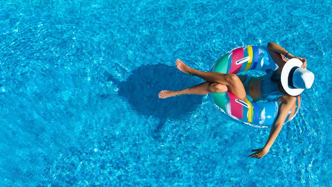 Woman swimming in an outdoor pool on a sunny day