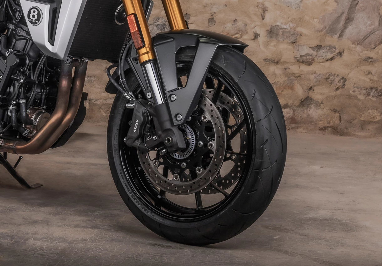 Suzuki GSX-8T front wheel and suspension close up in a barn