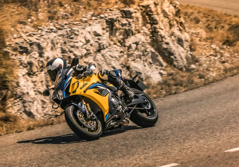 Suzuki GSX-R1000R braking into a corner downhill on a mountain road.