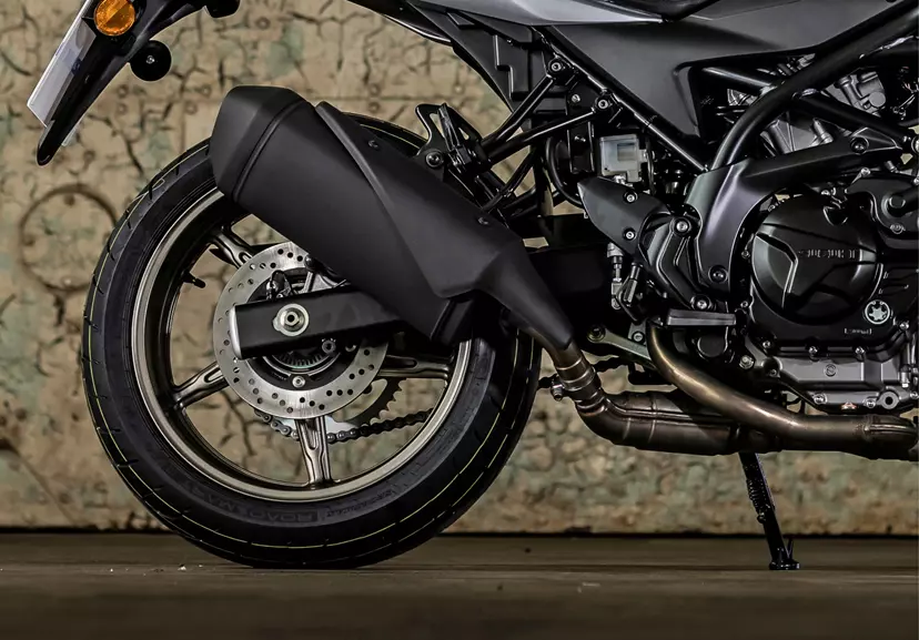 Suzuki SV650X exhaust system close up with hanger door background