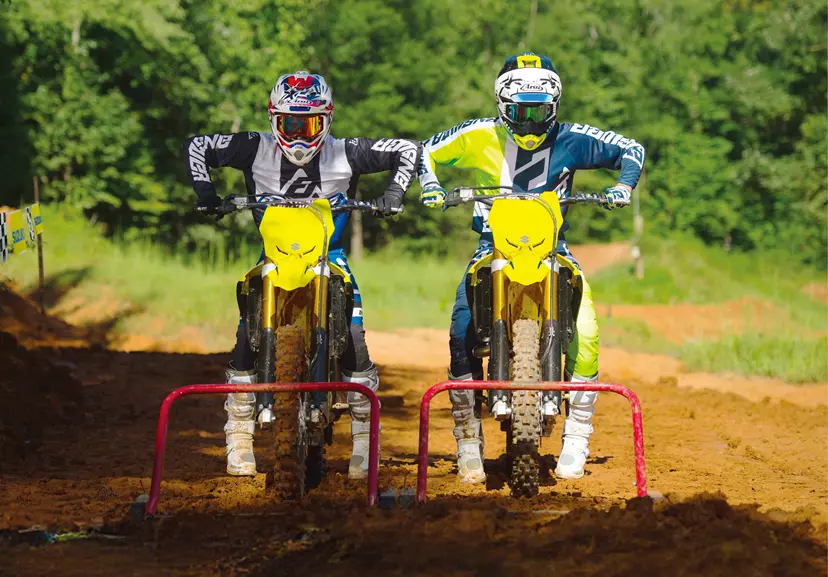 Suzuki RM-Z250 holeshot with another bike behind the start gate on a Motocross track