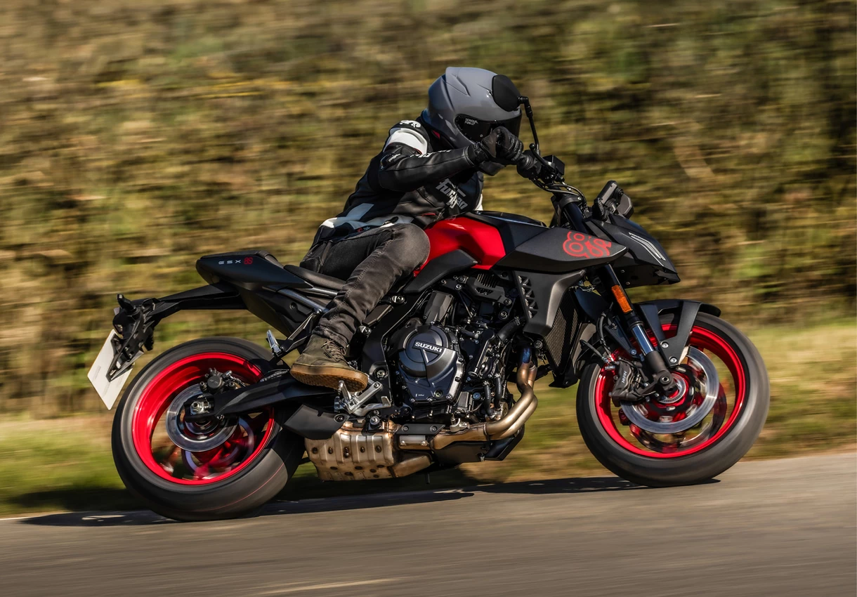 Suzuki GSX-8S black and red, cornering on a country road.