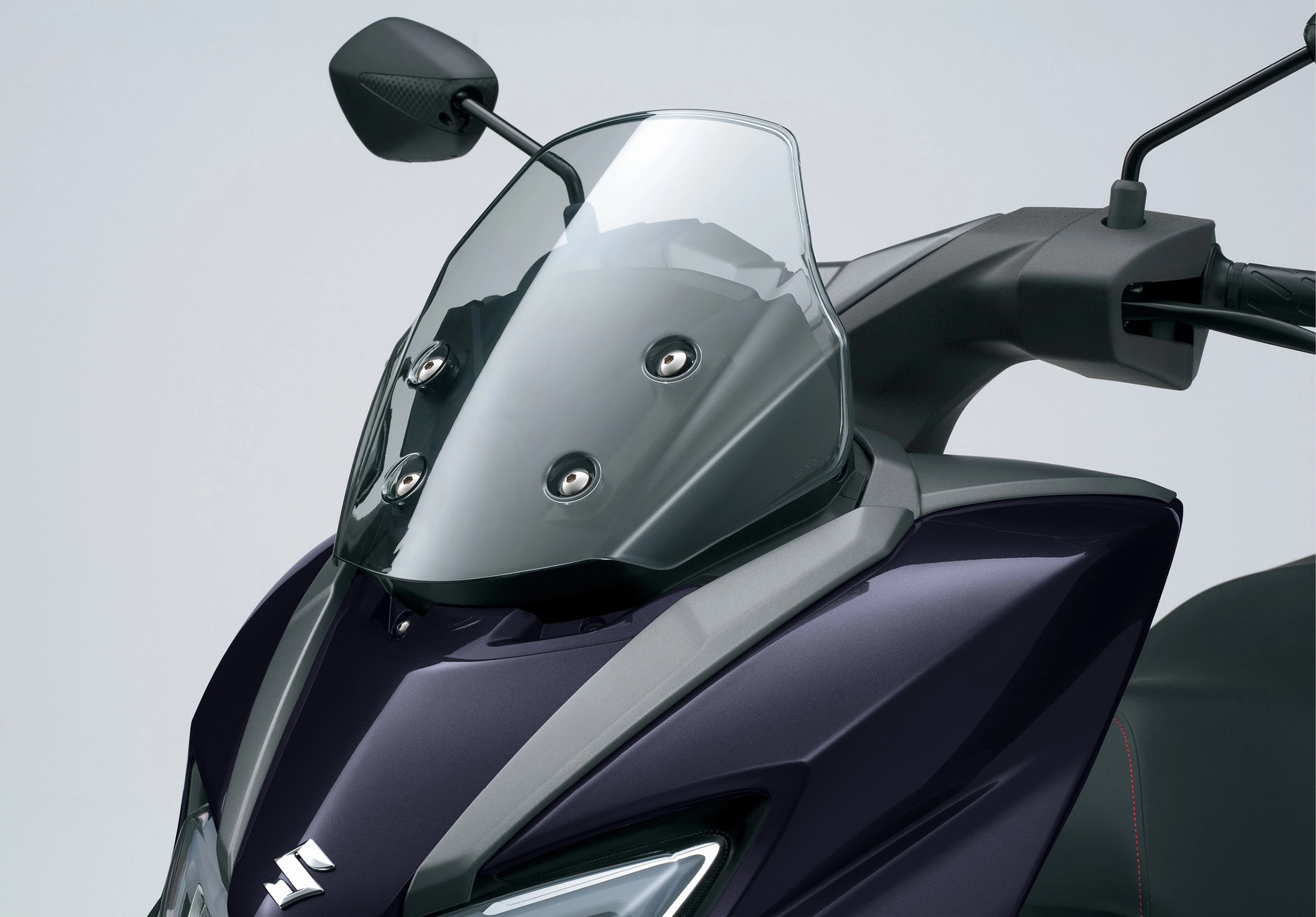 Suzuki Burgman Street 125EX close up of the front screen, showcasing its sharp design, integrated windscreen, and headlight details.