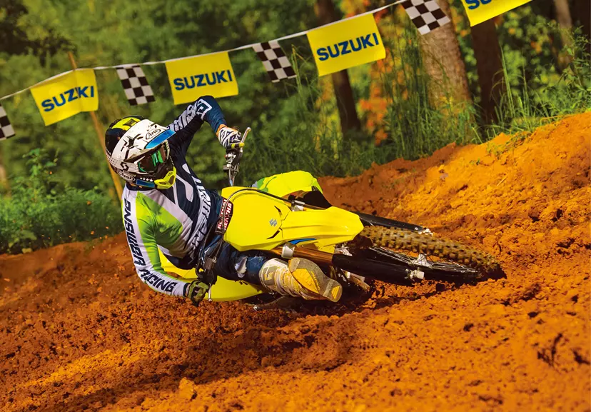 Suzuki RM-Z450 leant over backing in hard going around a corner on a Motocross track