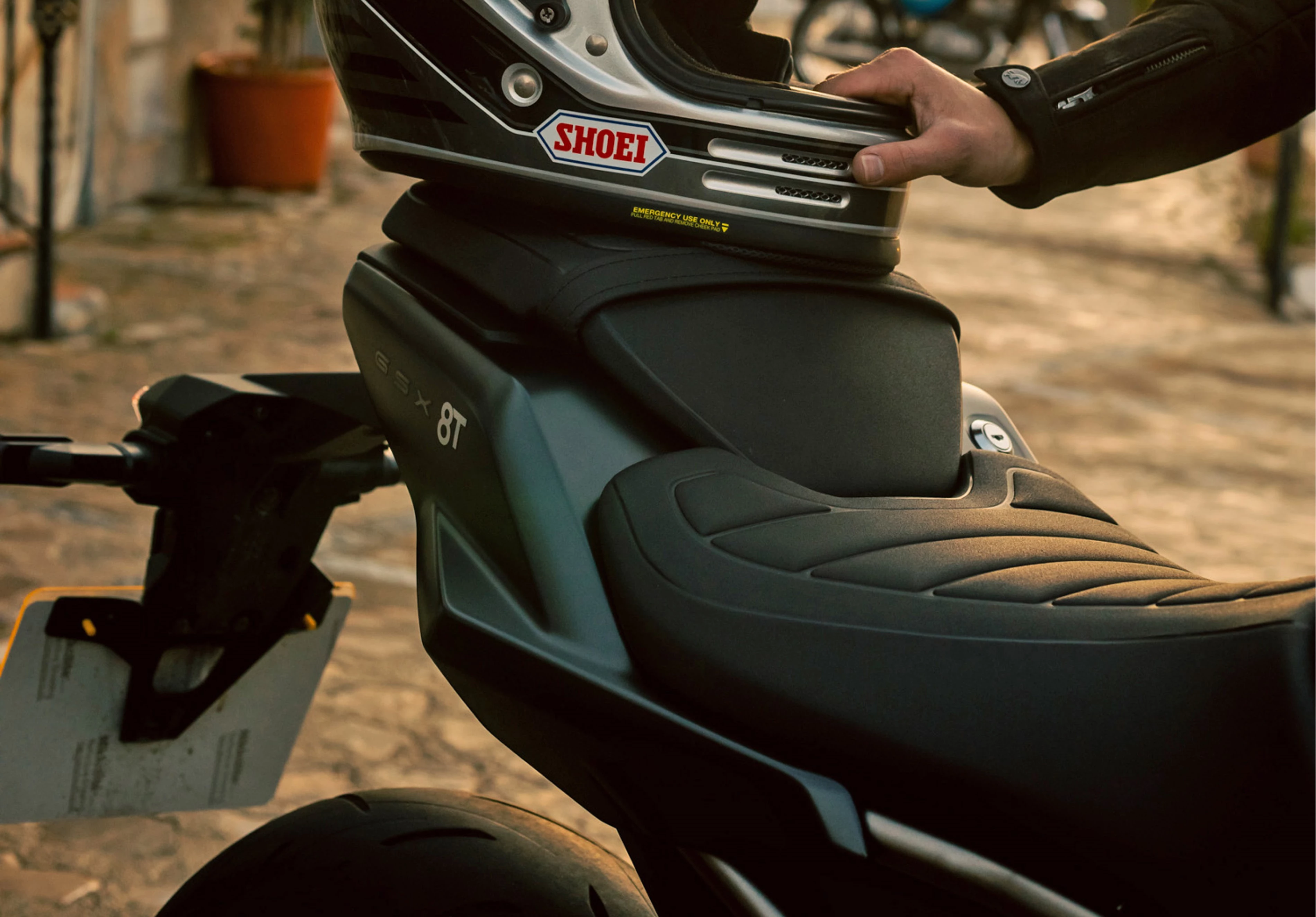 Suzuki GSX-8T rear seat with rider placing helmet on pillion seat on location