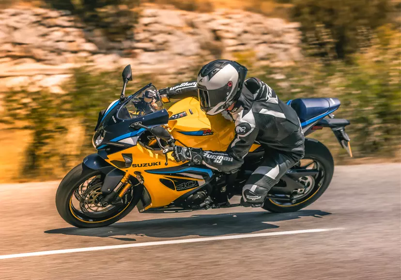 Suzuki GSX-R1000R left hand side leaning over into a corner on a mountain road.