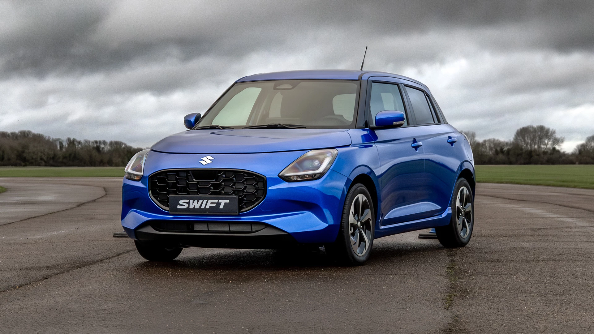 Front three-quarter view of the Suzuki Swift parked outdoors, highlighting its sculpted body lines and dynamic exterior styling