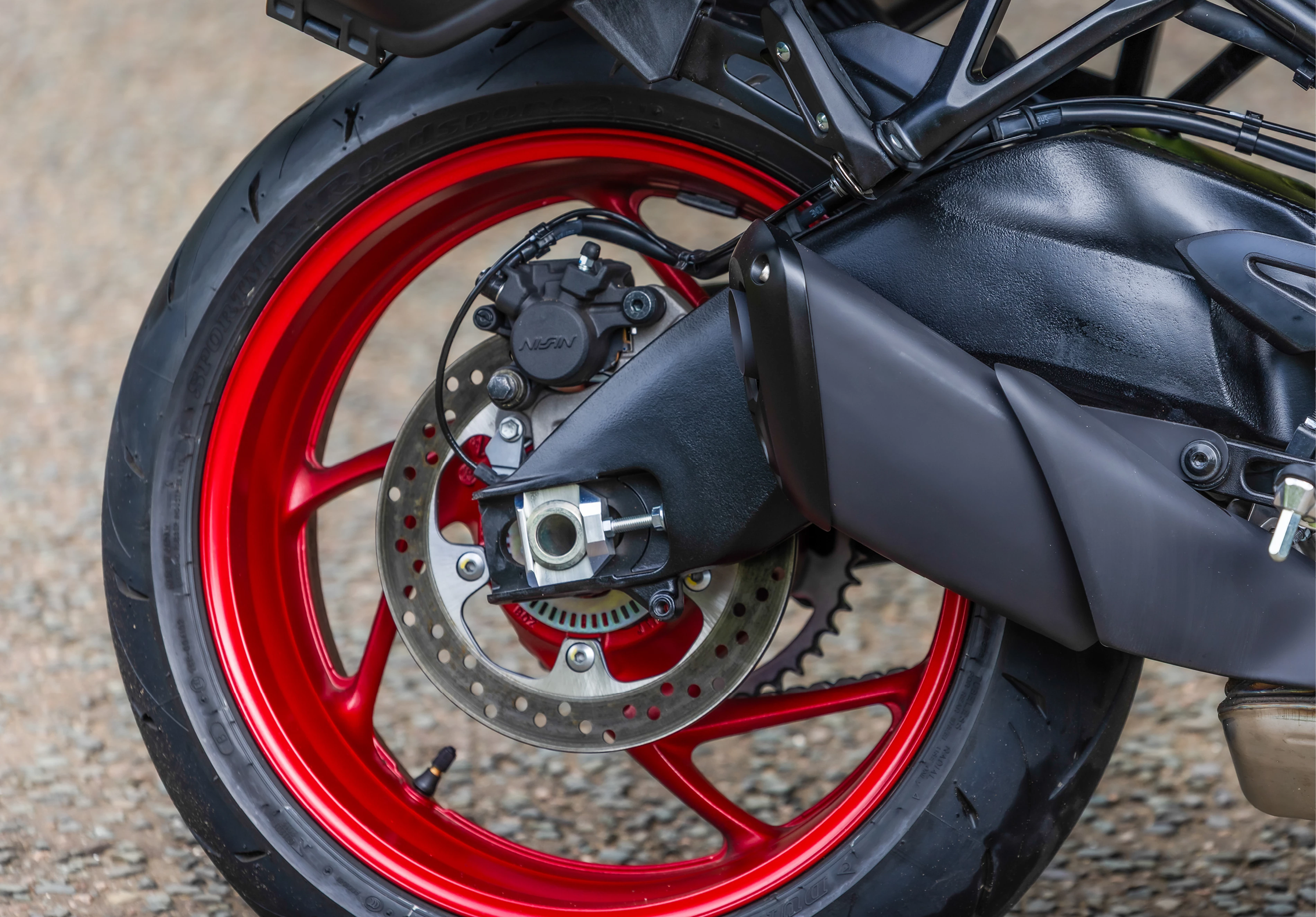 Suzuki GSX-S1000GX+ rear wheel and exhaust close-up.