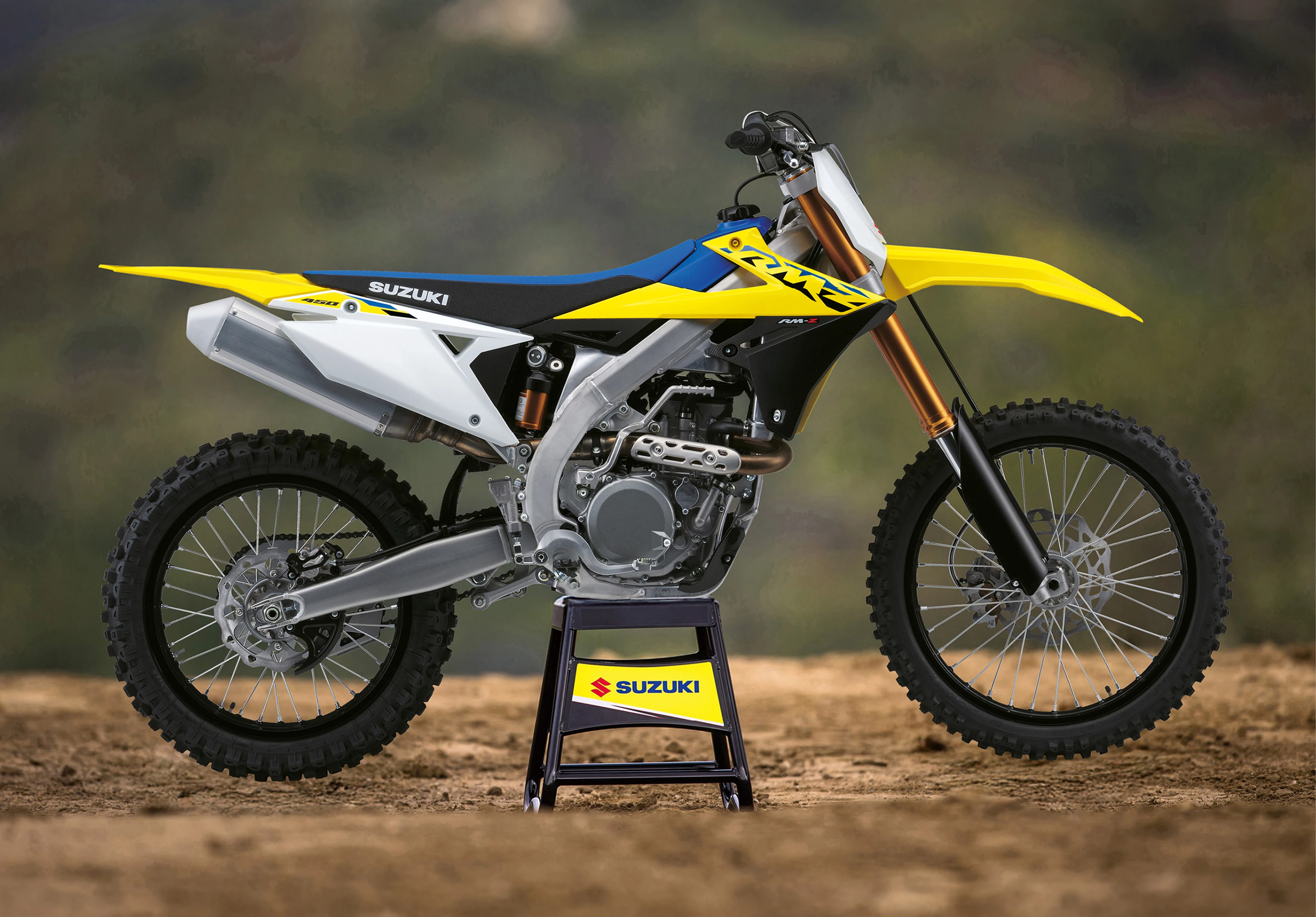 Suzuki RM-Z450 on a stand with mountains in the background